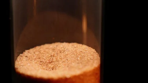 Sand slowly settles in a clear container, revealing unique patterns over time in Video stock 320525030