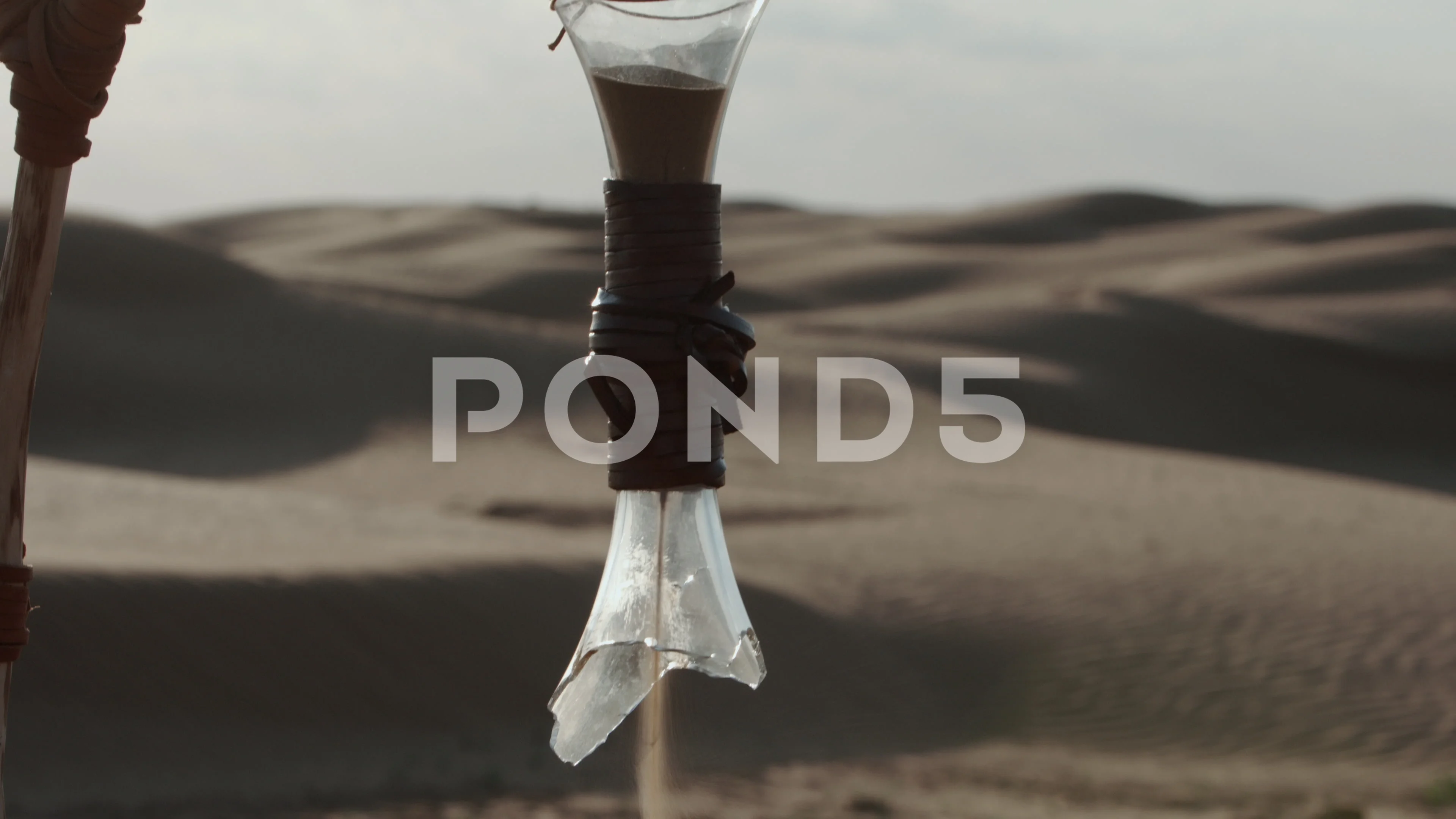 broken hourglass with sand pouring out