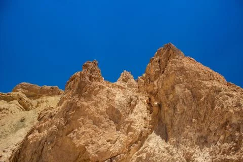 Sand stone desert rocks sharp edges natural shapes on vivid blue sky background  Stock Photos