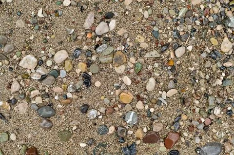 Sand surface covered with pebble and tiny stone fragments. Sand pattern cre.. Stock Photos