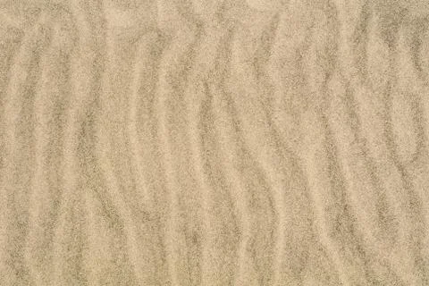 A sand texture, close-up macro view to a sand of a beach with shapes, waves a Stock Photos