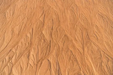 Sand texture with wavy lines and jets of water in warm colors Stock Photos