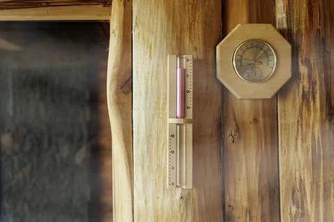 Sand timer and thermometer with hygrometer hanging on the wooden wall Stock-Fotos