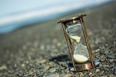 Sand timer on pebble beach Stock Photos