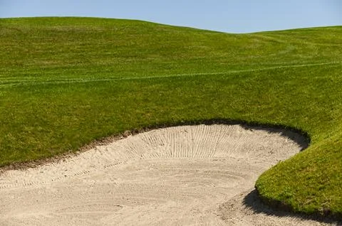 A sand trap on a golf course Stock Photos