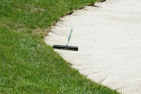 Sand trap rake in a bunker Stock Photos