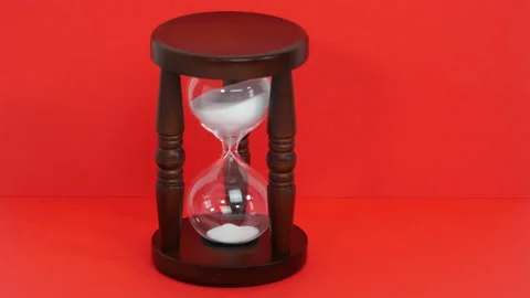 Sand watch on red background Stock Footage 151923833