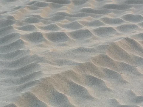 Sand waves pattern created by the wind on the beach Stock Photos