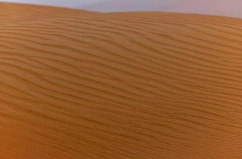 Sand waves on the red dunes in the desert near Dubai at sunrise Stock Photos