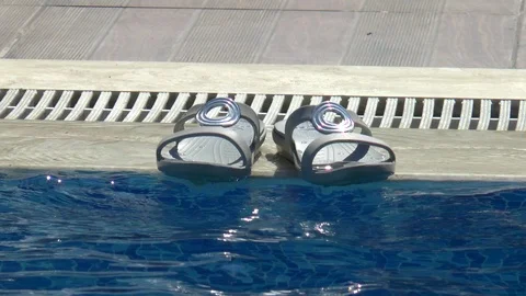 Sandals On The Edge Of A Swimming Pool Stock Footage 95783812
