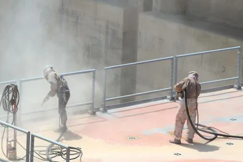 Sandblasting of metal structures at construction site Foto stock