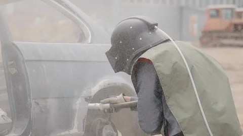 Sandblasting of metal surface of the car by compressed air of the sandblaster Stock Footage 128263231