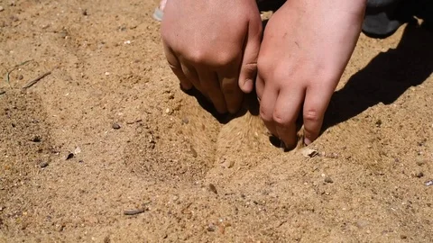 In the sandbox child and playing in the yellow sand in the summer heat Stock Footage 90391237
