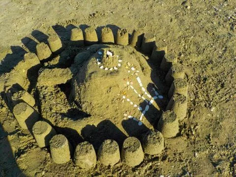 A sandcastle with shells on the beach Stock Photos