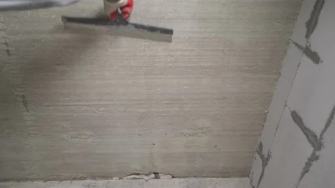 Sanding the ceiling before painting. A worker cleans the ceiling with a spatula Stock Footage 228482110