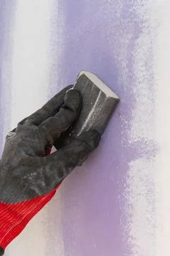 Sanding gypsum plaster by hand using sandpaper wall Stock Photos