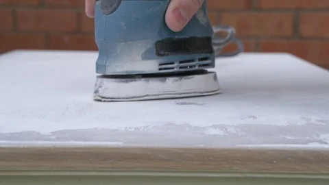 Sanding machine taking off layer of paint to get a cabinet back to wood. Stock Footage 106214807