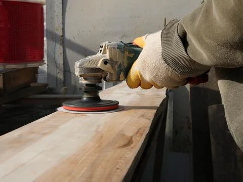 Sanding the surface of the board using a grinder Stock Photos
