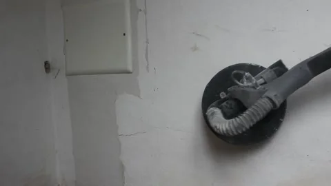 Sanding the wall with a machine before painting it Stock Footage 252233943