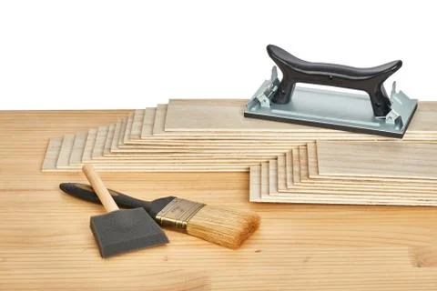 Sandpaper holder, stack of veneers and paint brushes Stock Photos