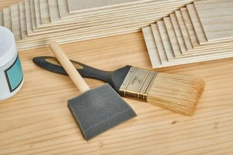 Sandpaper holder, stack of veneers and paint brushes Stock Photos
