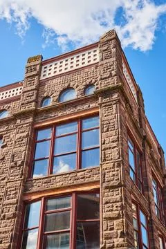 Sandstone Building Elegance with Arched Windows, Sunny Sky - Upward View Foto stock