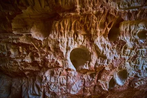 Sandstone Cave Wall Texture with Ancient Carvings and Natural Erosion Patterns Stock Photos