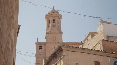 Sandstone church bell tower with octagonal lantern against clear blue sky Stock Footage 339645677