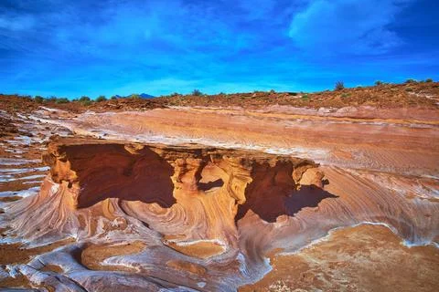 Sandstone Formations and Swirling Patterns in Vibrant Desert Landscape unde.. Stock Photos