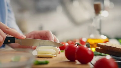 Sandwich bread, A young mother absorbed in the process cuts mozzarella in th Stock Footage 247833827