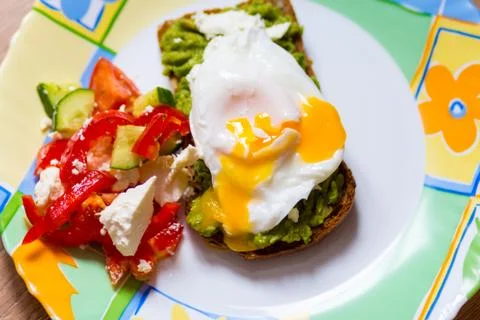 Sandwich from the broken eggs on black bread with paste of avocado. shallow Stock Photos