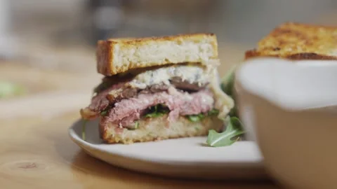 A sandwich is cut in half and placed on a white plate Stock Footage 305648192