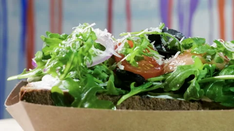 Sandwich with rye bread, salted salmon, cheese, vegetables and herbs. 4K Vidéo 97666861