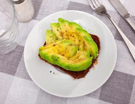 Sandwich with rye bread, sliced avocado and sesame Stock-Fotos
