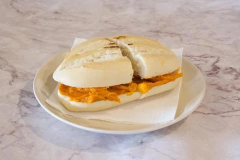 A sandwich with a slice missing is on a white plate Stock Photos