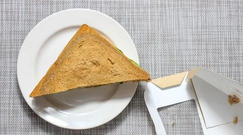 The sandwich is triangular, which was taken out of the package and put on a p Stock Photos