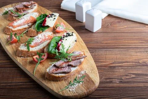 Sandwiches with red fish, beef in suvit and soft cheese. Garnished with slice Stock Photos