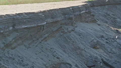 Sandy bank of river is gradually being destroyed by water flow. Stock Footage 252387143