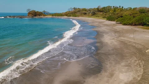 Sandy bay with gentle waves reaching an untouched tropical beach in Costa Rica Stock Footage 344772398