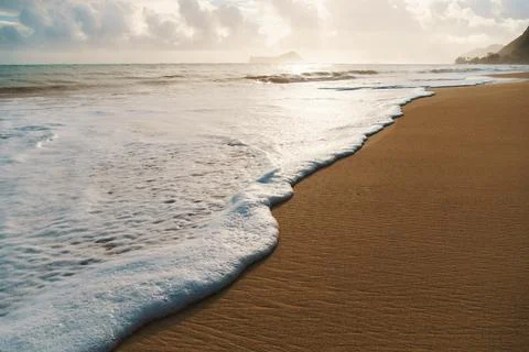 The sandy beach is adorned with waves creating a scenic natural environment Stock Photos