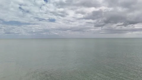 Sandy Beach and Calm Sea Under Cloudy Sky 4K Stock Footage 337846613