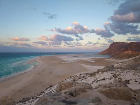 Sandy beach and cliffs under soft evening sky Stock Photos