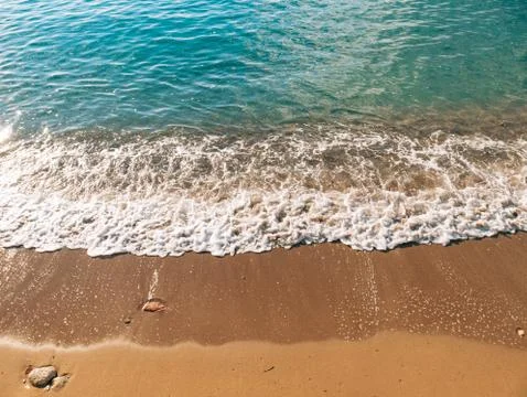 Sandy beach and waves, close-up. Texture of sand and water. Pict 스톡 사진