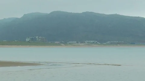 Sandy beach on the background of buildings and low mountains in the distance. Stock Footage 73464886