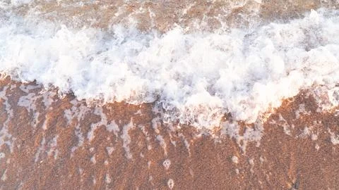 Sandy beach background with sea waves. Stock Photos