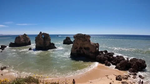 Sandy Beach, Blue Water, Rocks and a Passing boat, Praia dos Arrifes Algarve Stock Footage 335048006