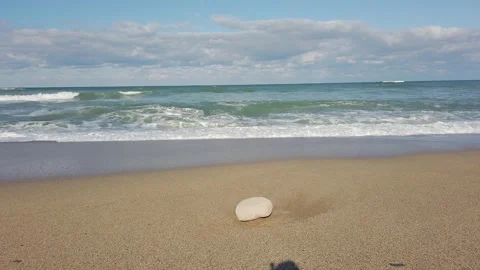 Sandy beach. Bright blue sky, white clouds. Windy. Large sea waves, white foam Stock Footage 144112468