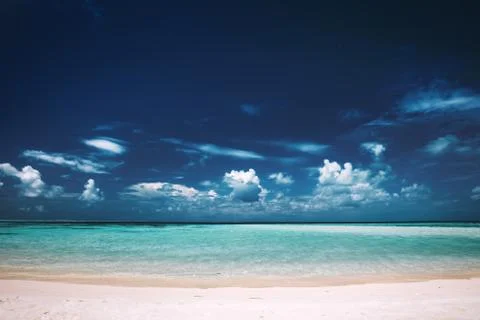Sandy beach, clear see-through sea and blue sky. Stock Photos
