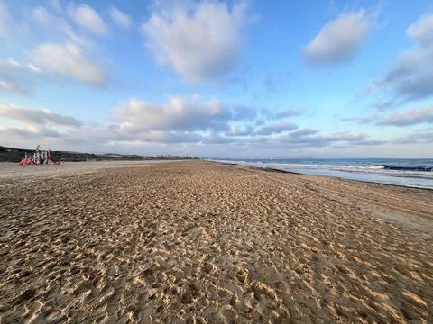 Sandy beach with clouds and sun Stock-Fotos