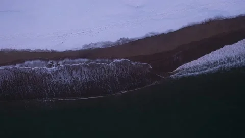 Sandy beach covered by snow and crashing waves Vídeo Stock 221226326